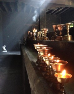 The soot of oil lamps clings heavy and black to all surfaces, balanced by the etherial mix of sunlight through makeshift skylights while cold falls winds howl outside the rudimentary door to this prayer room at  Shey monastery, south of Leh. 