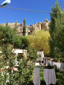 A modest view across the guesthouse's courtyard, looking up to the monastery through trees and a clothes line.