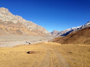 Within a km of reaching the Spiti river, I pause to take in the nice reds and lowering light of day. Ahead another 100 meters, i'll pull down nice and close to the rocky edge of the river, really just an infinite number of river stones with a handful of channels running past. My front tire hits a brisket shaped stone with a tapered point facing up and the gas strut shutters and grounds out; the back bounces over and I think I am so lucky. Another km later I hear the wobble of empty punctured rubber as my rear tire goes flat some 6 km from Losar.