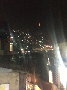 The lit monkey god atop the hill at night as seen (likely) from the mall.